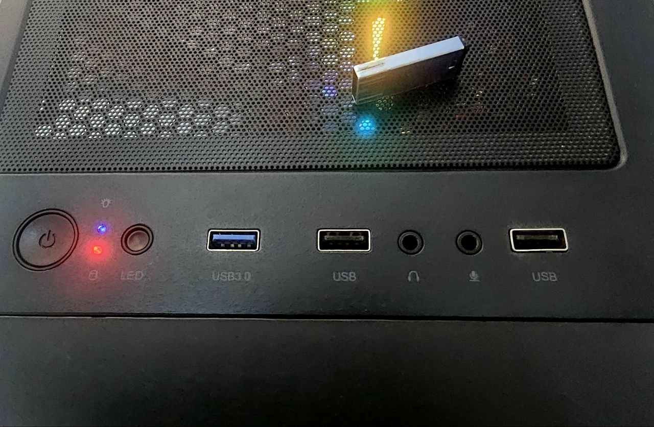 The front panel of the PC case: power button, indicator LEDs, a blue USB 3.0 port, a USB 2.0 port, headphone and microphone jacks, and a second USB 2.0 port